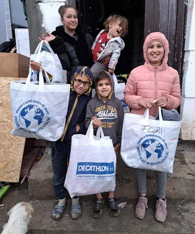 Copiii familiei Manea cu sacoșe de daruri primite prin donații