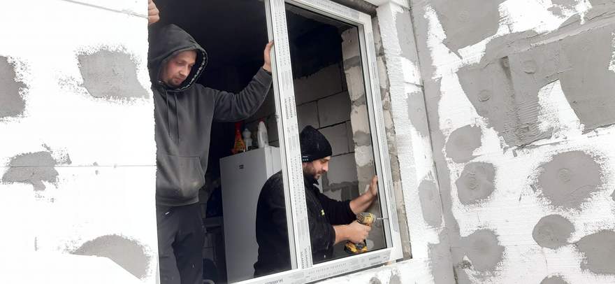 Voluntari montând o fereastră Salamander la casa familiei Manea